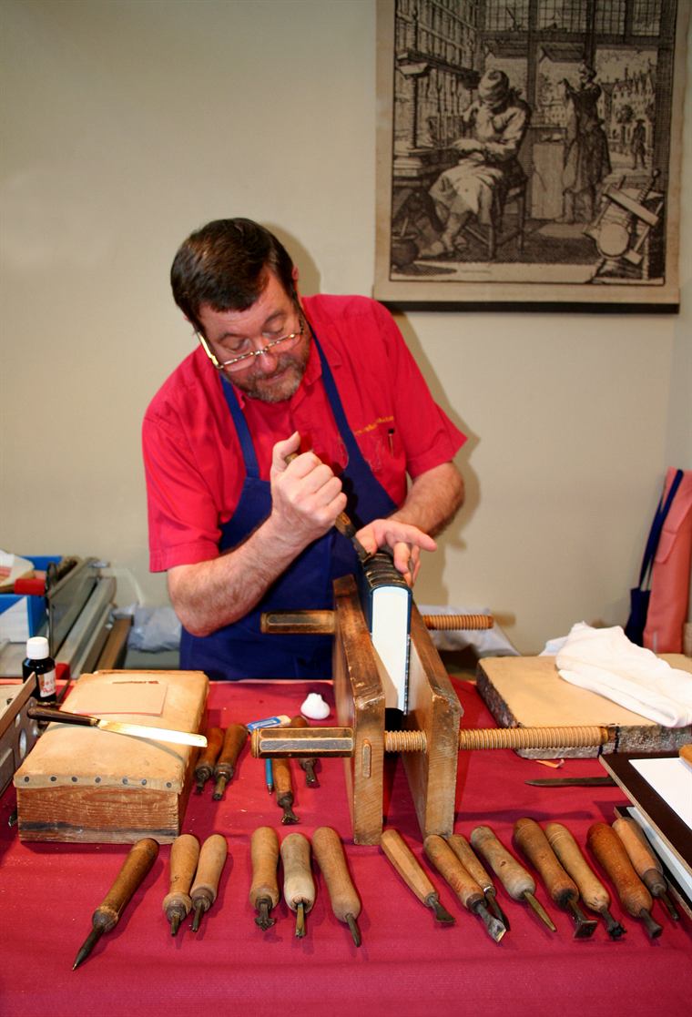 A book being sewn at the binding bench